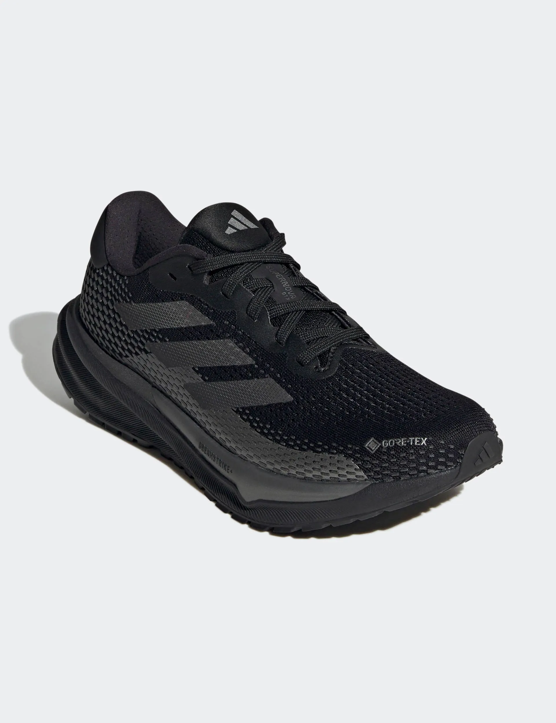 Supernova GORE-TEX Shoes - Core Black/Iron Metallic running in a marina area shoes